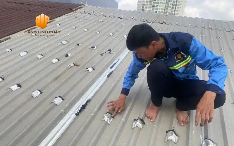 Công nhân kiểm tra vết trám lỗ bắn đinh mái tôn – xử lý chống thấm dột tại Bàu Bàng.